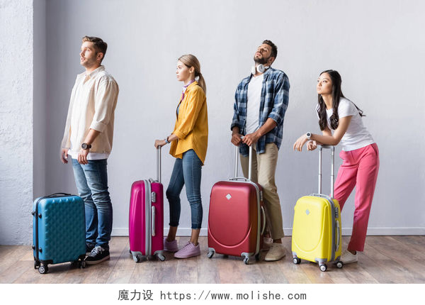 白色背景前拿着行李箱等待的四个人在机场大厅等行李的多族裔人士 